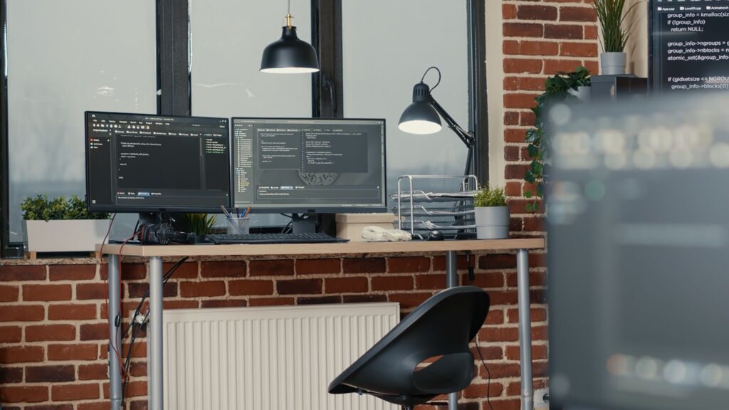 Desk with multiple computer monitors displaying parsing code